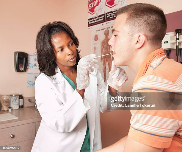 female doctor doing an exam on teen male patient. - youth new york screening stock pictures, royalty-free photos & images