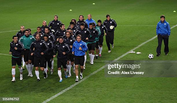 The players of Bursaspor warm up as the coach Ertugrul Saglam looks on during a training session at Old Trafford on October 19, 2010 in Manchester,...