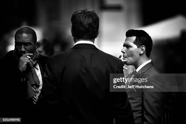As the world economy struggles to overcome a recession, men take a smoke break in the New York Stock Exchange area in the heart of New York's...