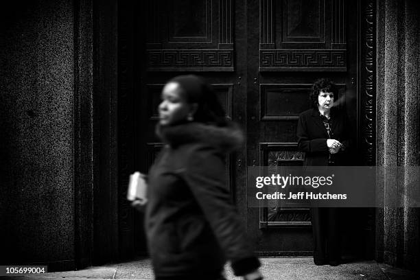 As the world economy struggles to overcome a recession, a woman takes a smoke break outside the New York Stock Exchange in the heart of New York's...