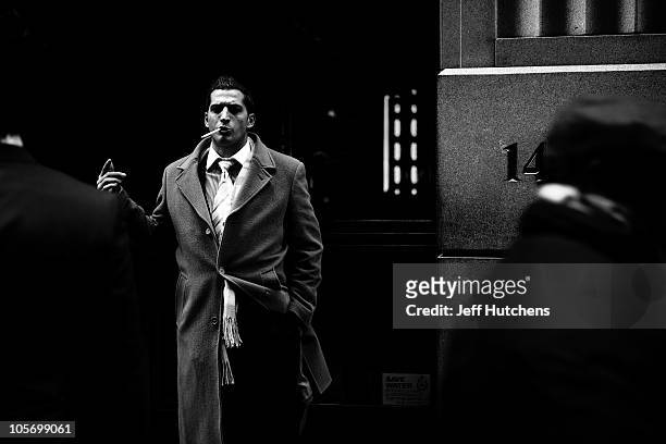 As the world economy struggles to overcome a recession, men take a smoke break in the New York Stock Exchange area in the heart of New York's...