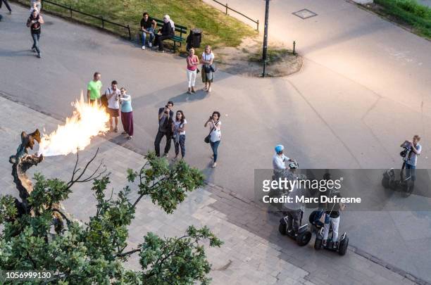 people looking at wawel dragon spitting fire in krakow, poland seen from above during summer night - wawel cathedral stock pictures, royalty-free photos & images