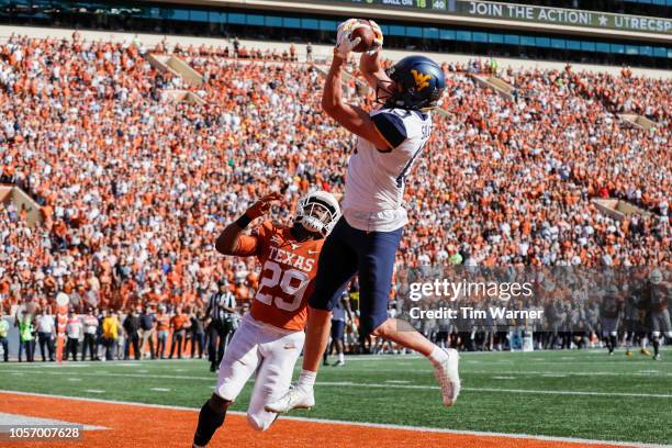 David Sills V of the West Virginia Mountaineers catches a pass for a touchdown defended by Josh Thompson of the Texas Longhorns in the second quarter...