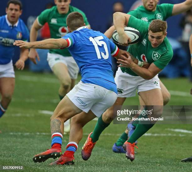 Jordan Larmour of ireland breaks a tackle attempt by Luca Sperandio of Italy on his way to a try at Soldier Field on November 3, 2018 in Chicago,...