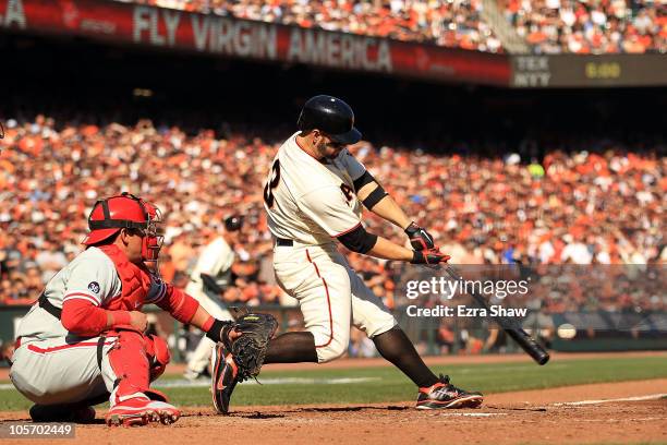 Cody Ross of the San Francisco Giants hits an RBI single against Cole Hamels of the Philadelphia Phillies in the fourth inning of Game Three of the...