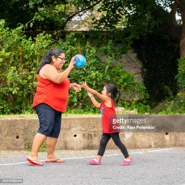die körper-positiv, fröhlich glücklich latino, mexikanisch-amerikanischen frau ballspielen im freien mit ihrer kleinen tochter - hot mexican girls stock-fotos und bilder