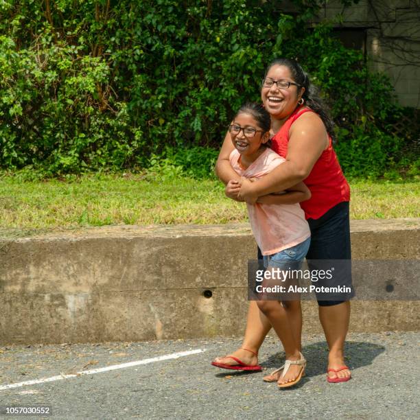 latino, mexican-american body-positive woman hugging her daughter outdoor - hot mexican girls stock pictures, royalty-free photos & images