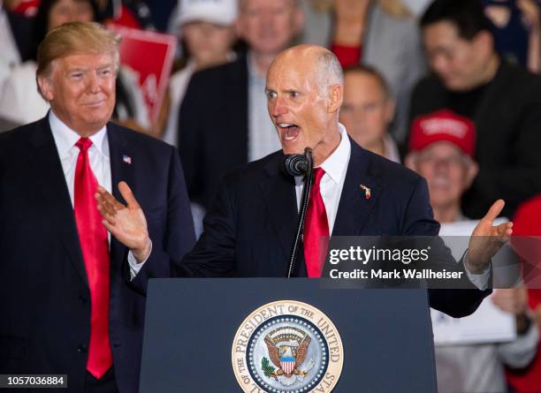 Florida governor and US Senatorial candidate Rick Scott speaks with U.S. President Donald Trump at a campaign rally at the Pensacola International...