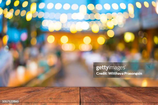 image of wooden table in front of abstract blurred restaurant lights background. - vintage restaurant ストックフォトと画像