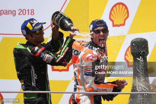 Repsol Honda Team Spanish rider Marc Marquez celebrates on the podium with Monster Yamaha Tech 3 team French rider Johann Zarco after winning the...