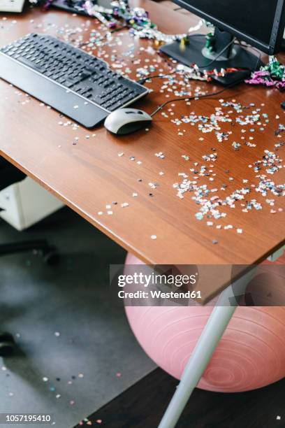 desk with confetti and streamers on computer after a birthday party - birthday streamers stockfoto's en -beelden