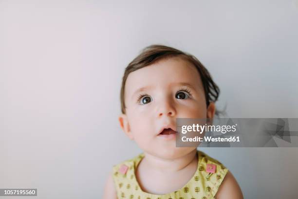 surprised baby girl looking up on white background - mystical baby girls stock pictures, royalty-free photos & images