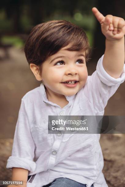 portrait of smiling toddler raising his finger - child raised arms age 3 stock pictures, royalty-free photos & images