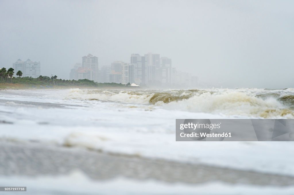 USA, Florida, Naples, Vanderbilt Beach, waves and spray after hurricane Harvey in front of hotel buildings