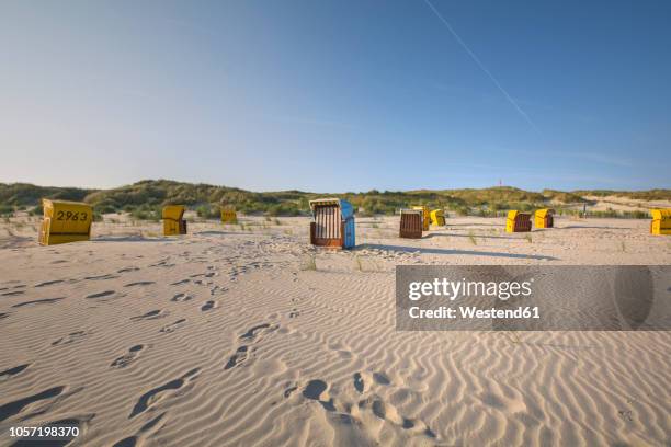 germany, lower saxony, east frisian island, juist, hooded beach chairs on the beach - east frisian islands stock pictures, royalty-free photos & images