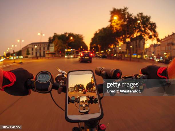 france, versailles, personal perspective of man riding e-bike on avenue de l'europe at twilight - grandangolo tecnica fotografica foto e immagini stock