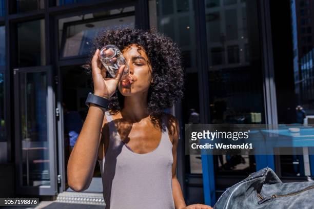young woman drinking lemonade in the city - softdrinks bottle stock-fotos und bilder