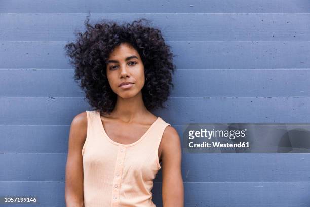 portrait of young woman with curly black hair - afro frisur stock-fotos und bilder