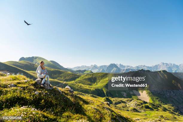 germany, bavaria, oberstdorf, mother and little daughter on a hike in the mountains having a break looking at view - bavaria summer stock pictures, royalty-free photos & images