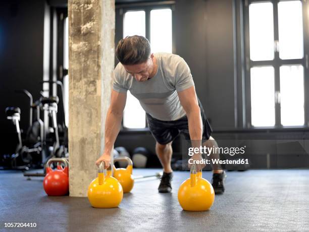 man doing pushups on kettlebells at gym - exercise room stock pictures, royalty-free photos & images