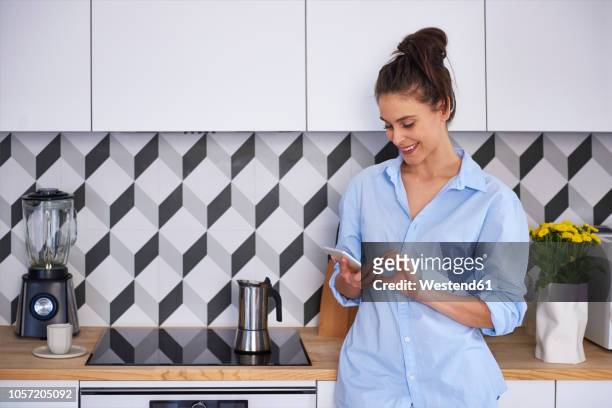 young woman preparing coffee in the morning, using smartphone - cooker dial stock pictures, royalty-free photos & images