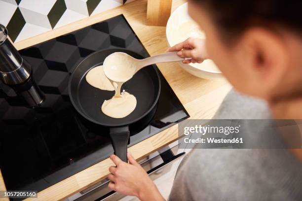 young woman preparing pancakes - pancakes stockfoto's en -beelden