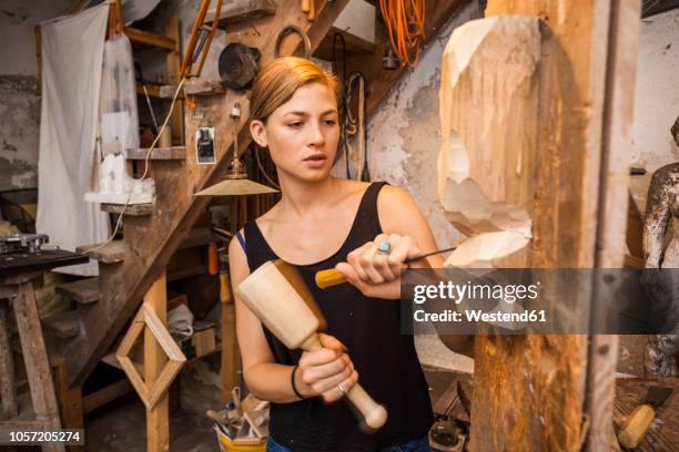 sculptress carving wooden figure - sculptor fotografías e imágenes de stock