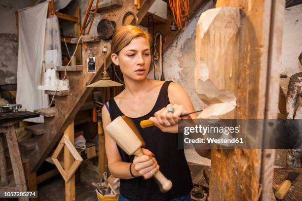sculptress carving wooden figure - escultura imagens e fotografias de stock