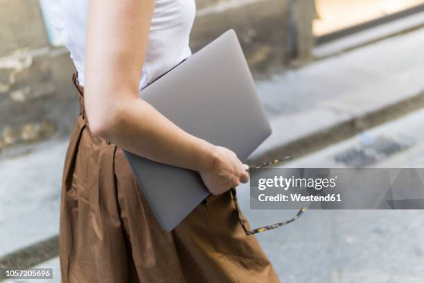 close-up of woman carrying laptop outdoors - woman carrying stock pictures, royalty-free photos & images