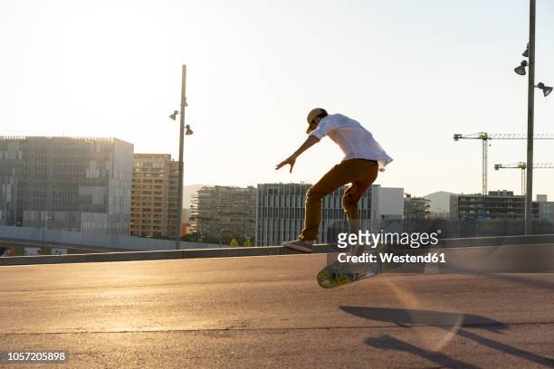 young man riding skateboard in the city - fall fashion event bildbanksfoton och bilder