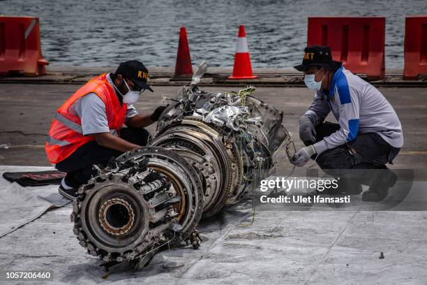 Indonesian investigators inspect the wreckage of an engine from Lion Air Flight JT 610 recovered from the sea at the Tanjung Priok port on November...