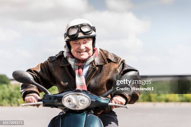 active senior man speeding on his motor scooter - motorino foto e immagini stock