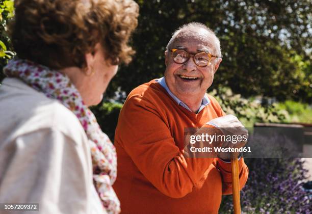 senior couple sitting on bench in a park, talking - chatting park stockfoto's en -beelden