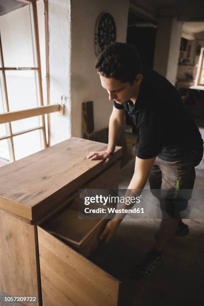 carpenter in workshop testing chest of drawers - bureau design imagens e fotografias de stock