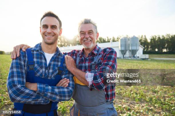 portrait of two farmers proud of their farm - two parents photos et images de collection