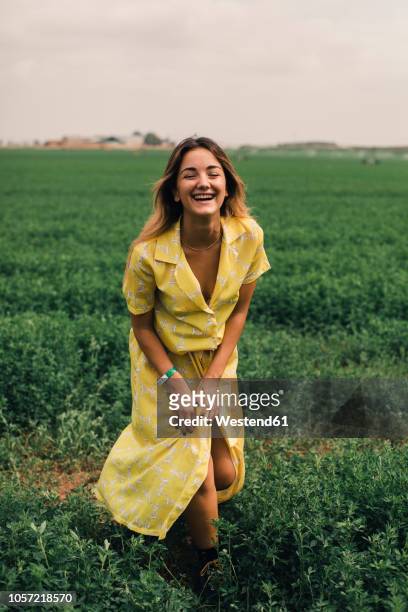 young woman walking in a green field - yellow dress stock pictures, royalty-free photos & images