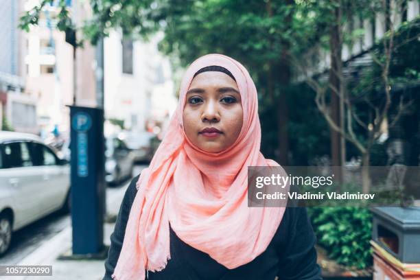 frau mit hijab gehen auf der straße - indonesian culture stock-fotos und bilder