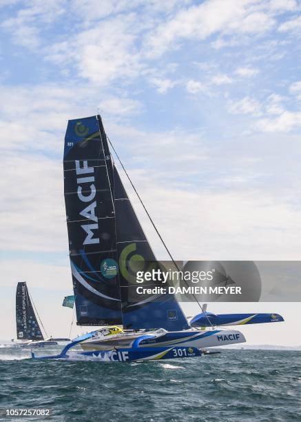 French skipper François Gabart Ultim maxi-trimarans "Macif" sails in front of French skipper Armel Le Cleac'h's "Banque Populaire IX" off the coast...