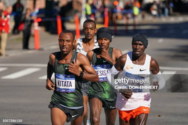 Lelisa Desisa of Ethiopia runs with Geoffrey Kamworor of Kenya and Ethiopian Shura Kitata during the Men's Division during the 2018 TCS New York City...