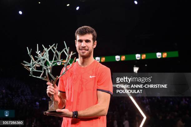 Russia's Karen Khachanov poses with the trophy after winning against Serbia's Novak Djokovic, the men's singles final tennis match on day seven of...
