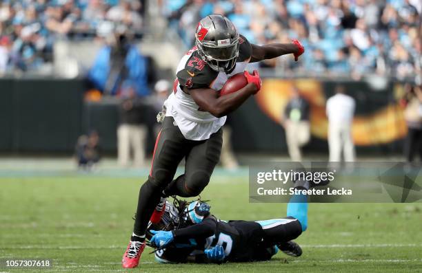 Peyton Barber of the Tampa Bay Buccaneers runs the ball against Donte Jackson of the Carolina Panthers in the second quarter during their game at...