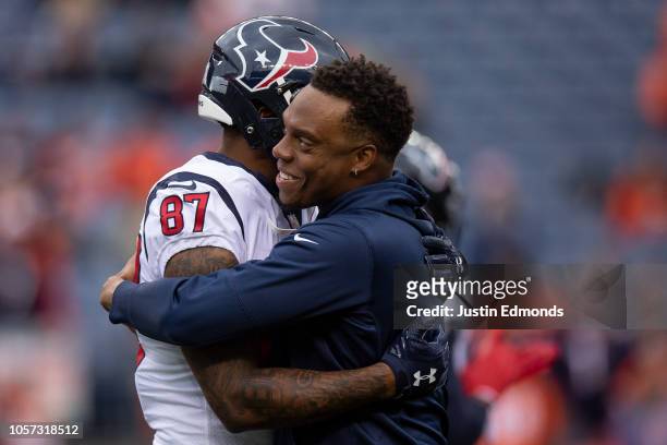 Wide receiver Demaryius Thomas of the Houston Texans talks with inside linebacker Brandon Marshall of the Denver Broncos during warm ups before a...