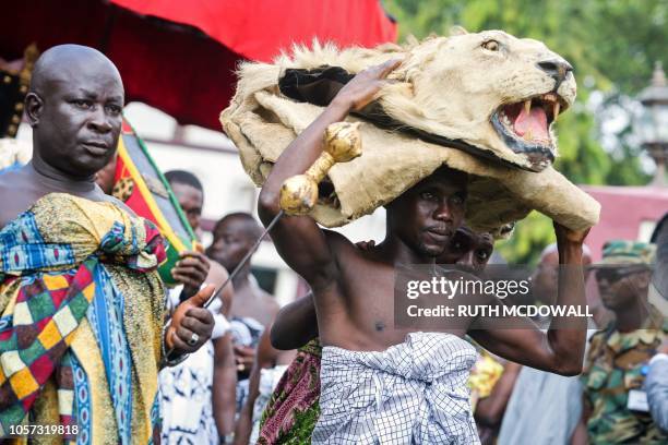 Man holding a stuffed lion head looks on during a visit of Britain's Prince Charles, Prince of Wales and his wife Britain's Camilla, Duchess of...