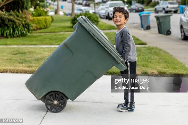 niño sacando basura - bote de basura fotografías e imágenes de stock