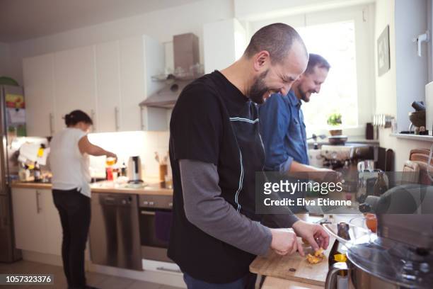 adults preparing dinner in a family kitchen - cooking with friends stock-fotos und bilder