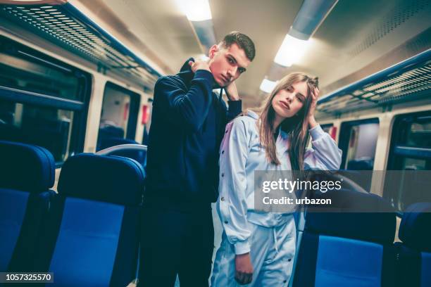 teenager mann und frau im zug - trainingsanzug stock-fotos und bilder