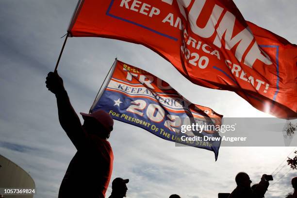 Supporter of President Trump waves flags outside of McKenzie Arena, where U.S. President Donald Trump is holding a rally in support of Republican...