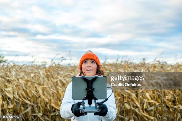 donna pilota utilizzando telecomando drone con un montaggio tablet - ripresa di drone foto e immagini stock
