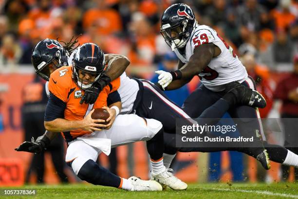 Quarterback Case Keenum of the Denver Broncos is sacked by outside linebacker Jadeveon Clowney of the Houston Texans in the fourth quarter of a game...