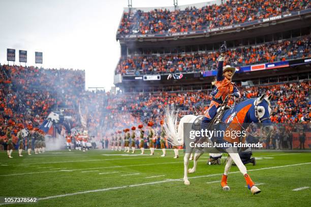 Denver Broncos mascot Thunder is ridden onto the field by Ann Judge before a game between the Denver Broncos and the Houston Texans at Broncos...